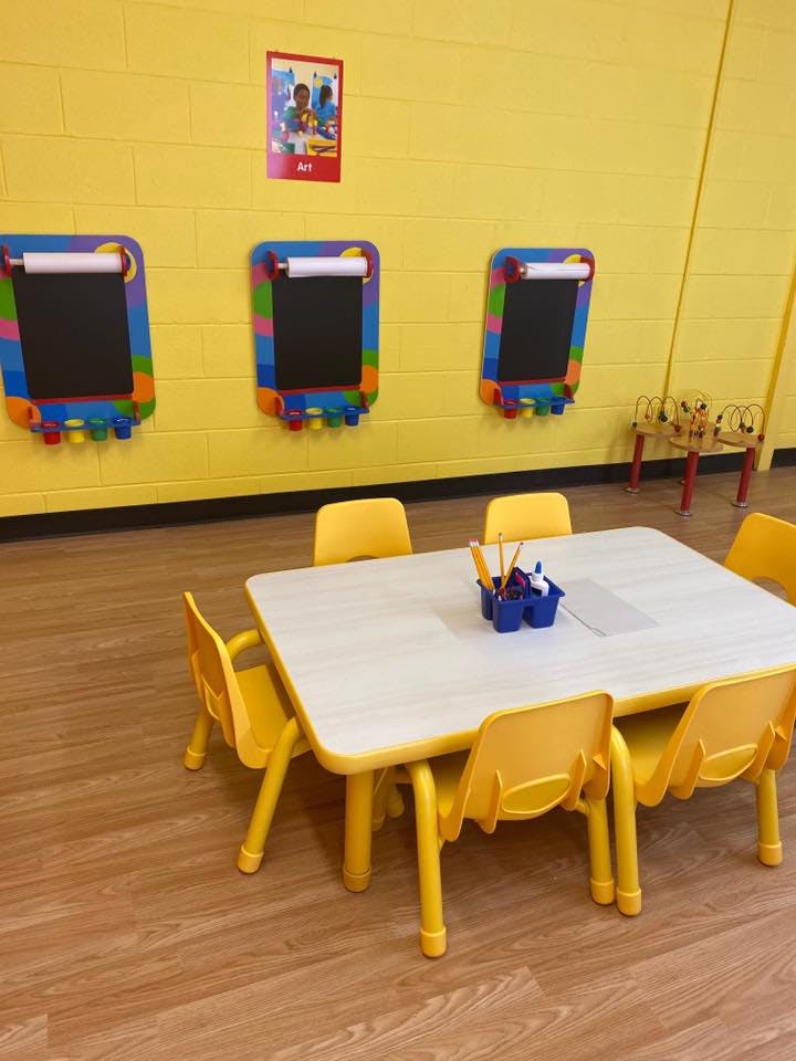 Classroom with small table and chairs, and drawing boards on the wall