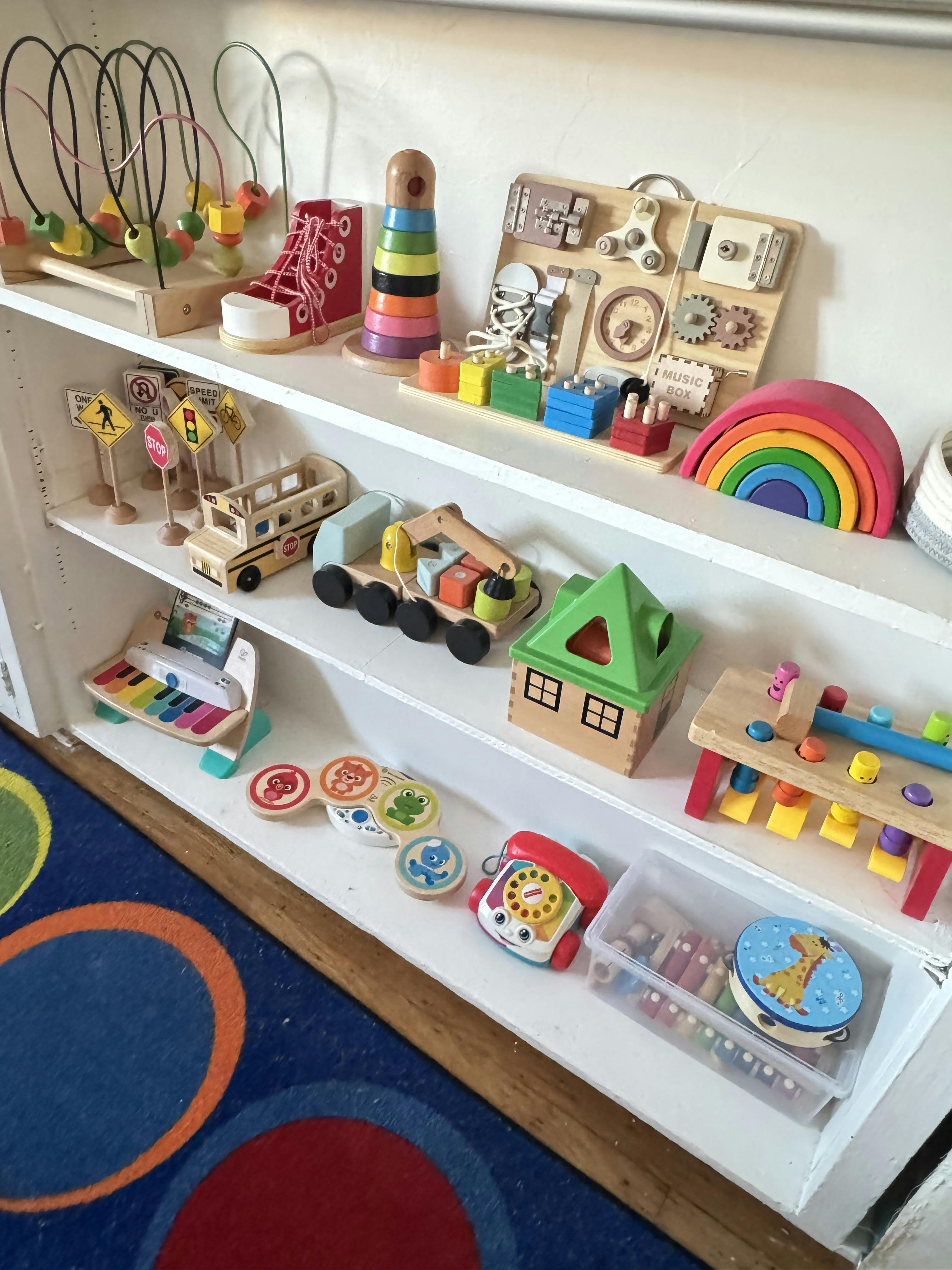 white shelves filled with various wooden and colorful children's toys