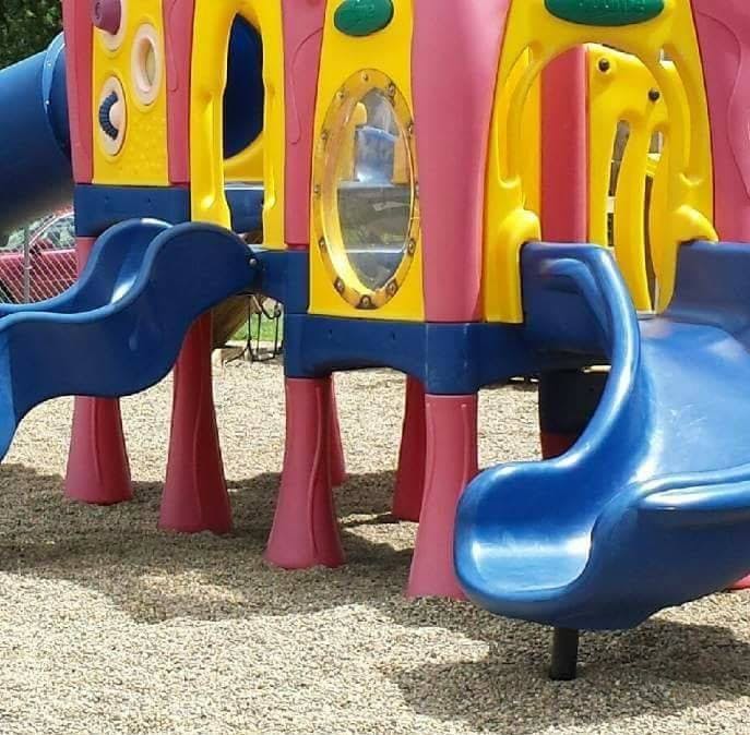 Colorful playground structure with blue slides and yellow and pink panels