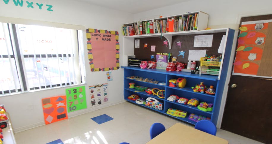 Classroom with a window, blue shelving unit, and educational posters