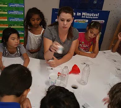 Adult and children at a table with bottles and cups