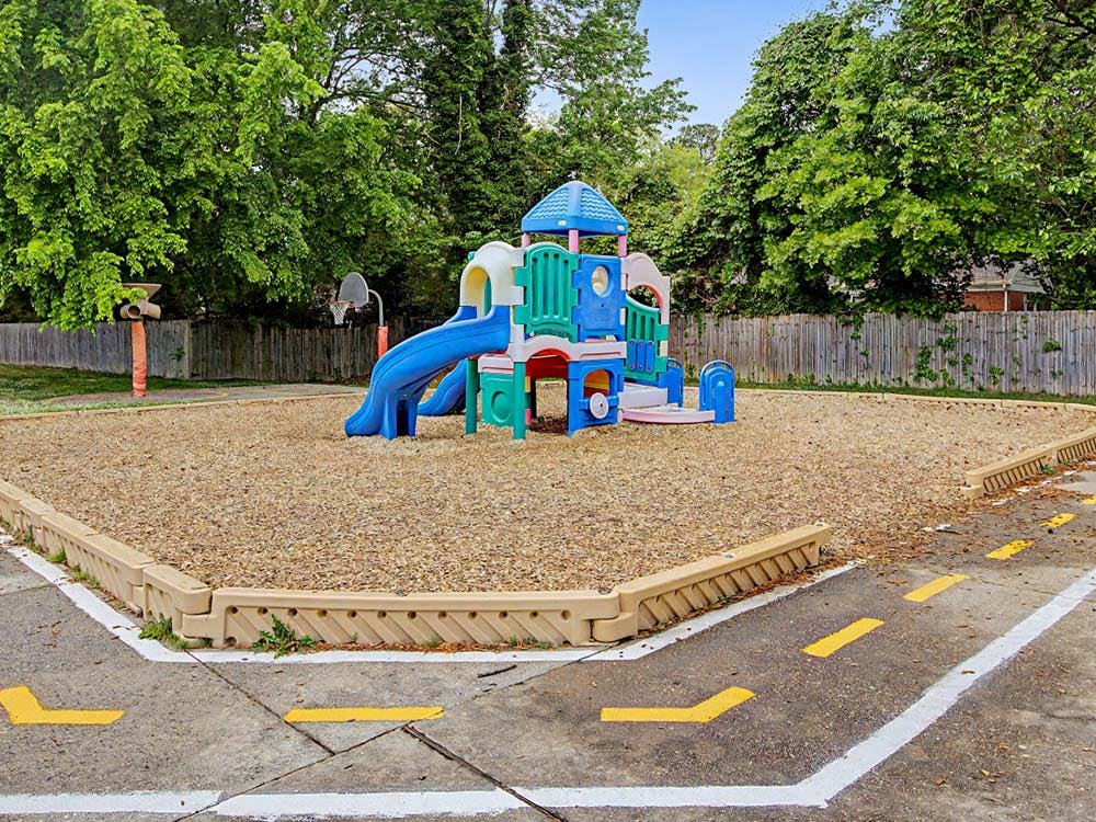 Colorful playground structure with slides on wood chip ground