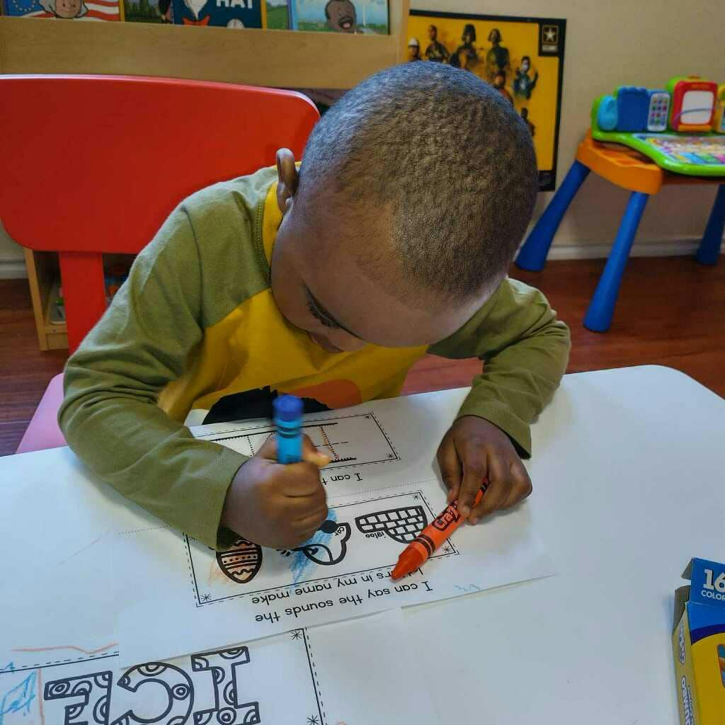 Child coloring a worksheet at a table