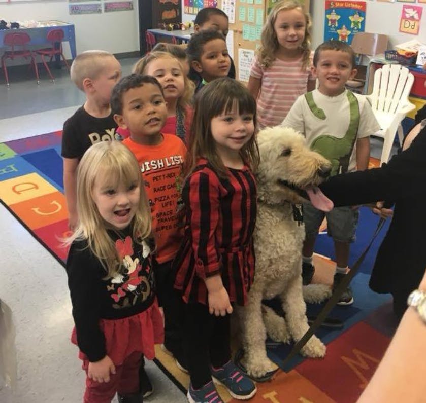 Children and a dog in a classroom