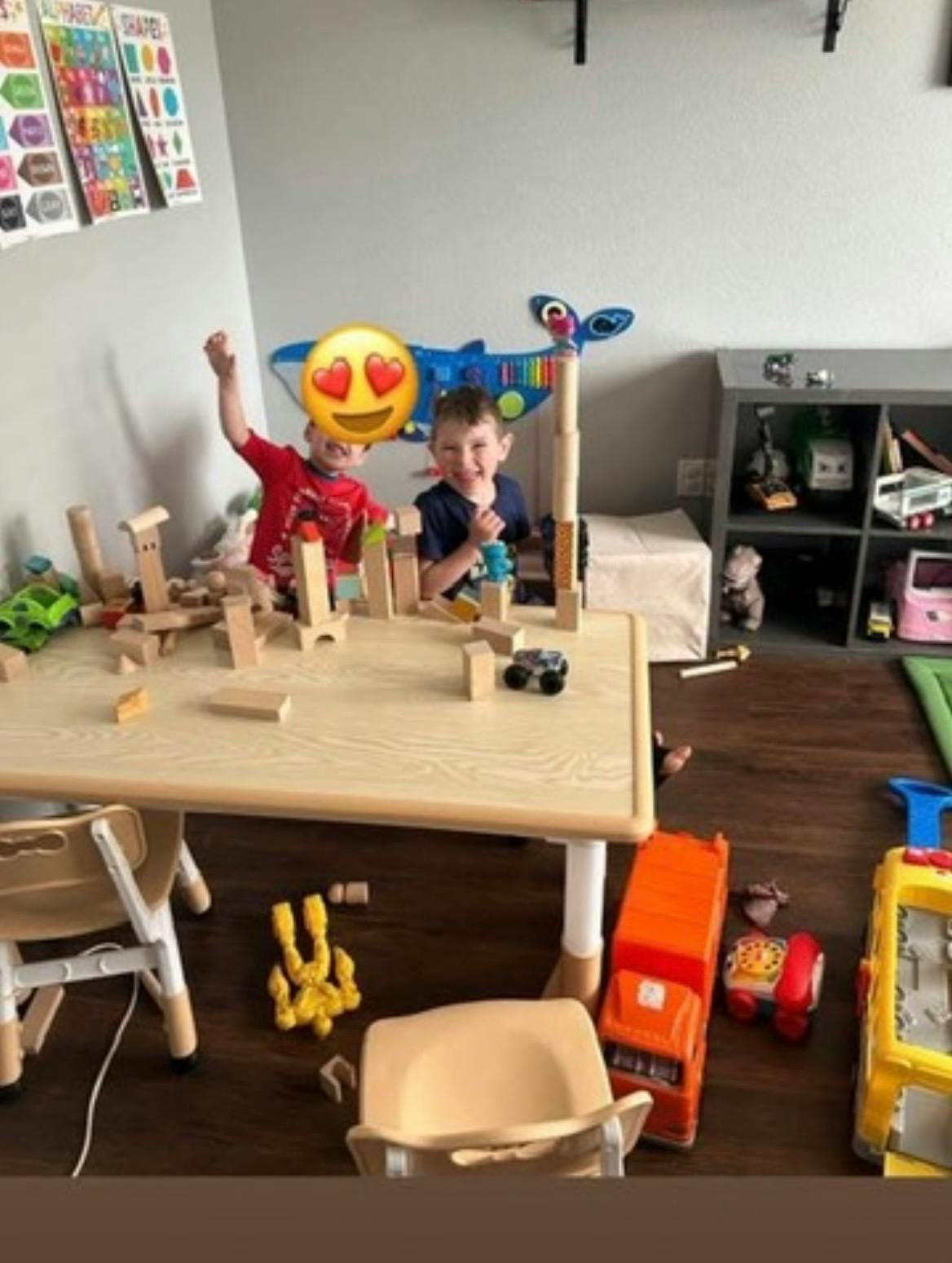 Two children playing with wooden blocks at a table