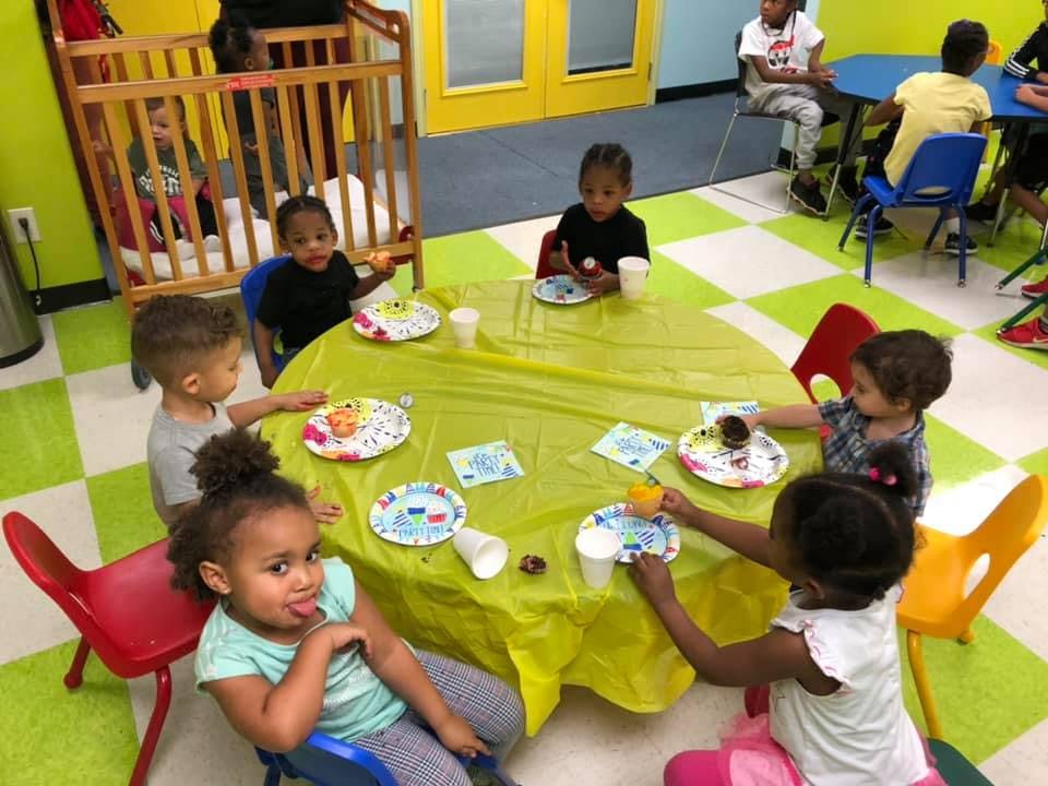 Children sitting around a table with plates and cups