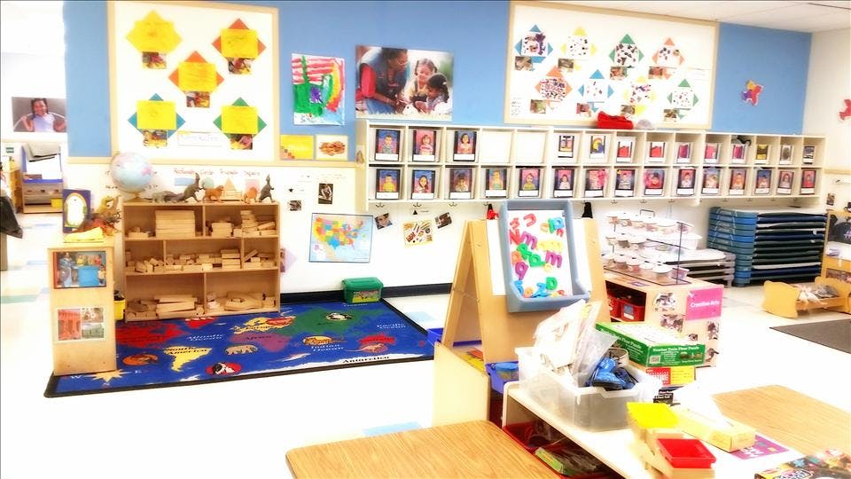 Classroom with shelves of wooden blocks and toys, an alphabet easel, and colorful artwork