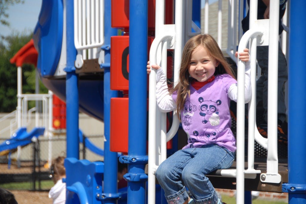 Child sitting on playground equipment