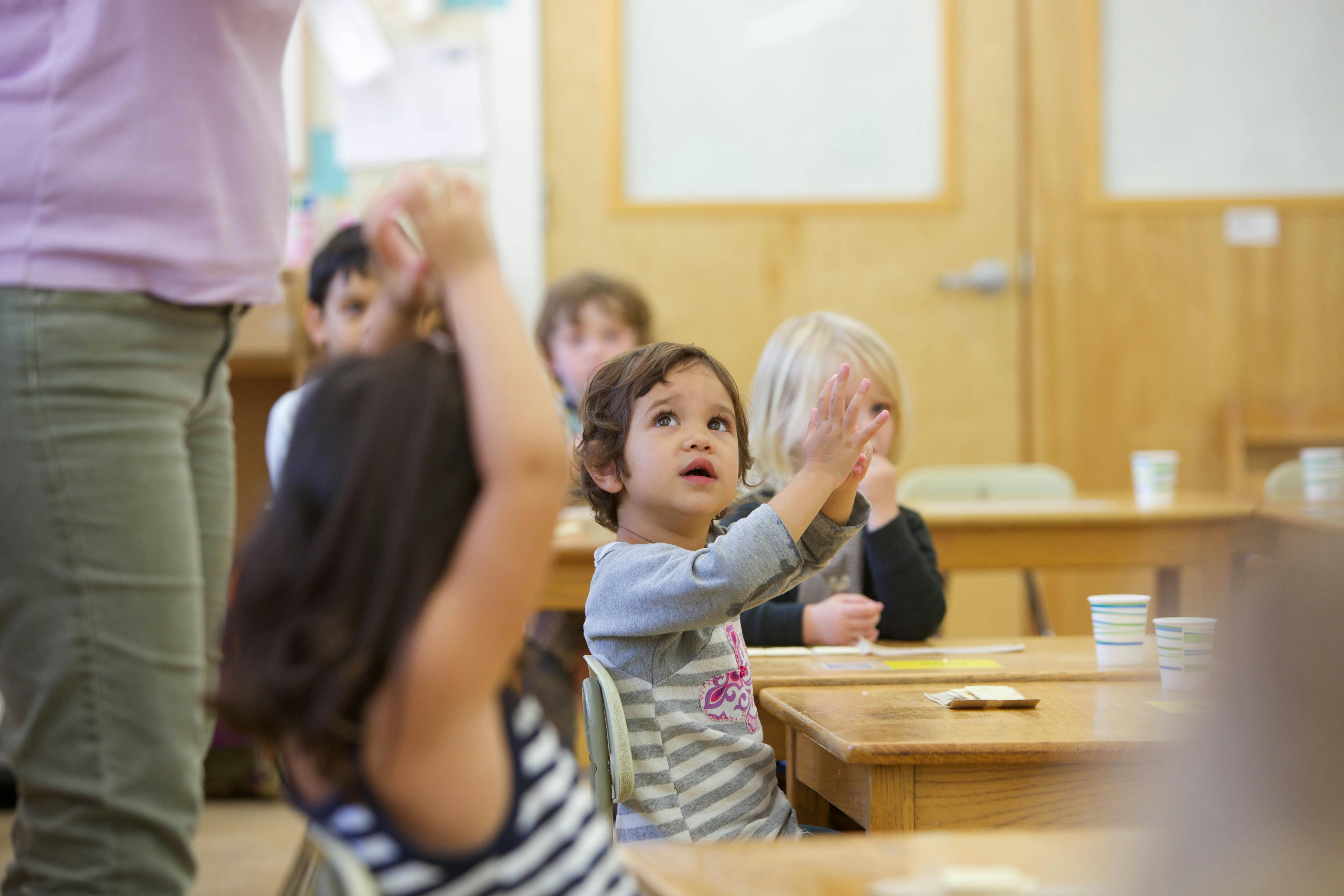 Child raising hand in a classroom