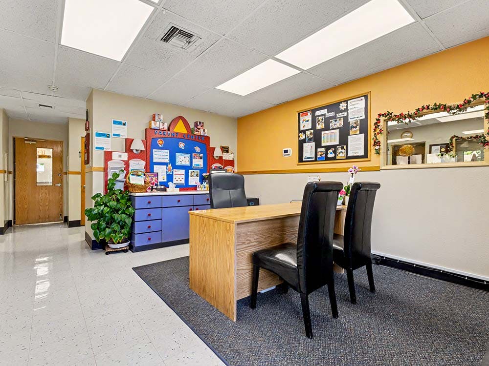 An office lobby with a reception desk, chairs, and a 'Parent Center' display