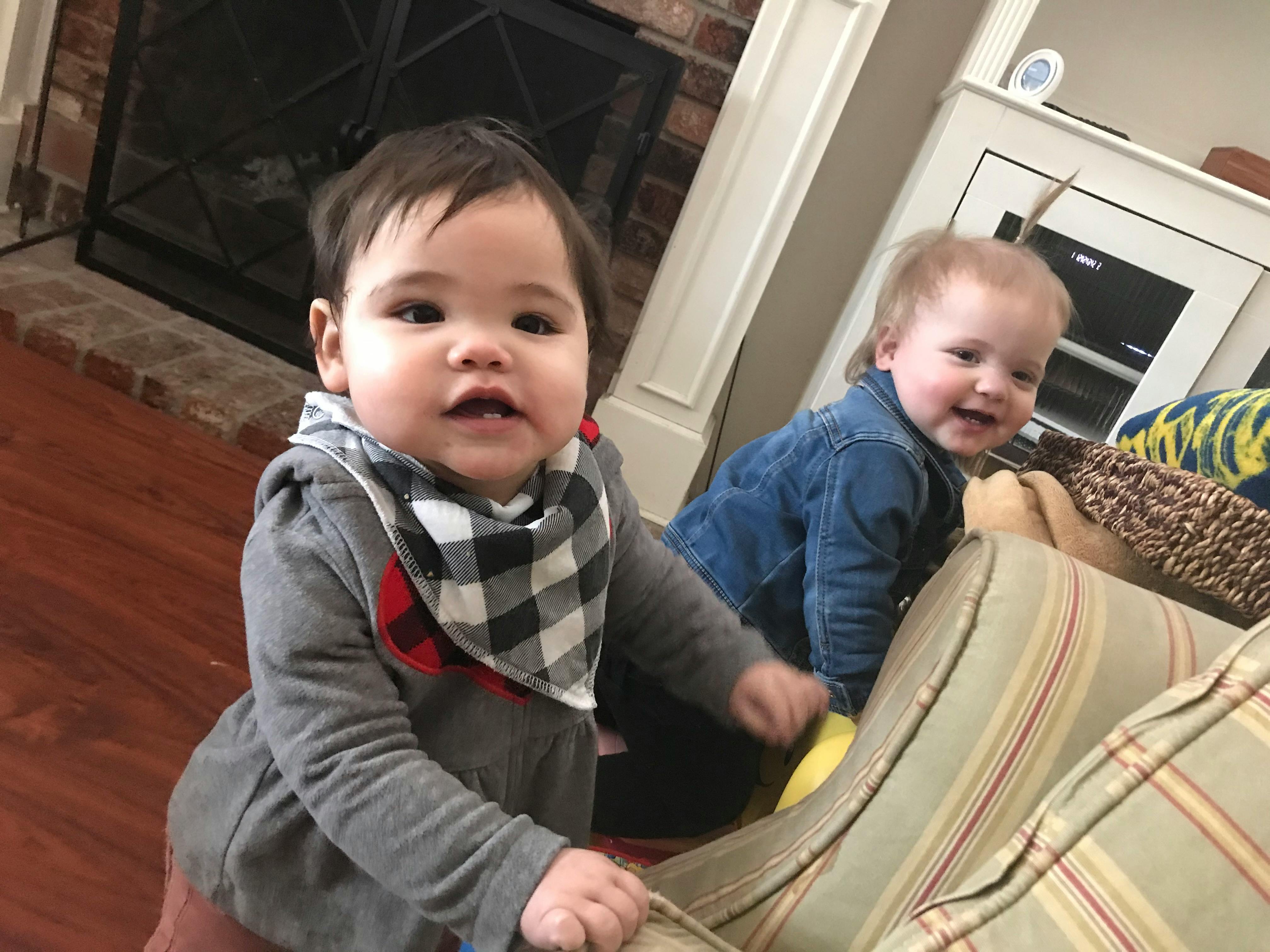 Two children playing near a couch in a living room