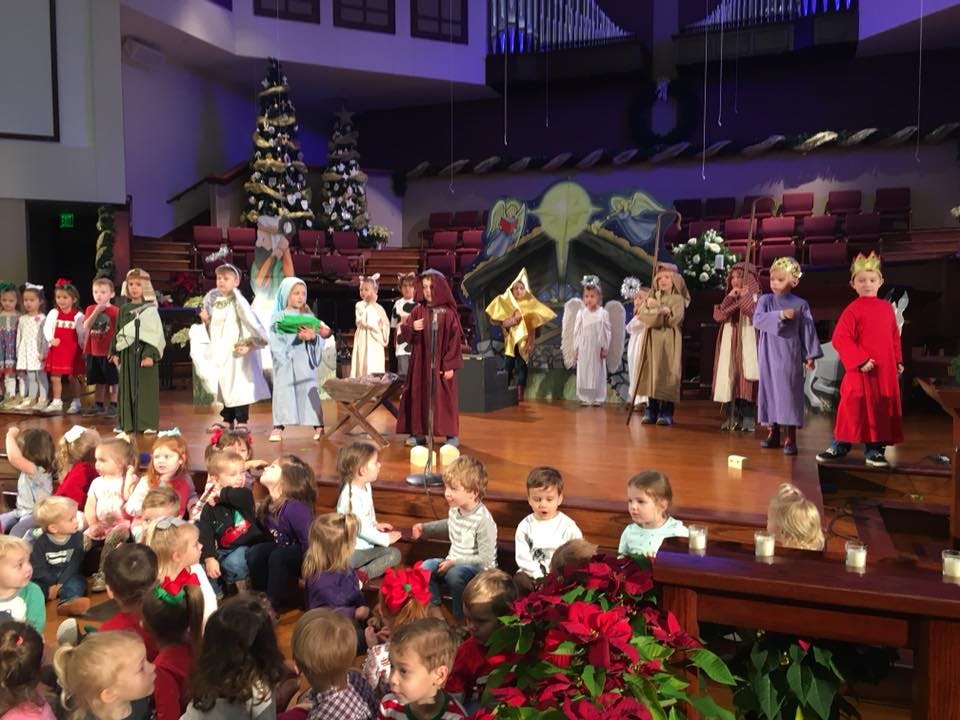 Children in costumes performing a nativity play on a stage