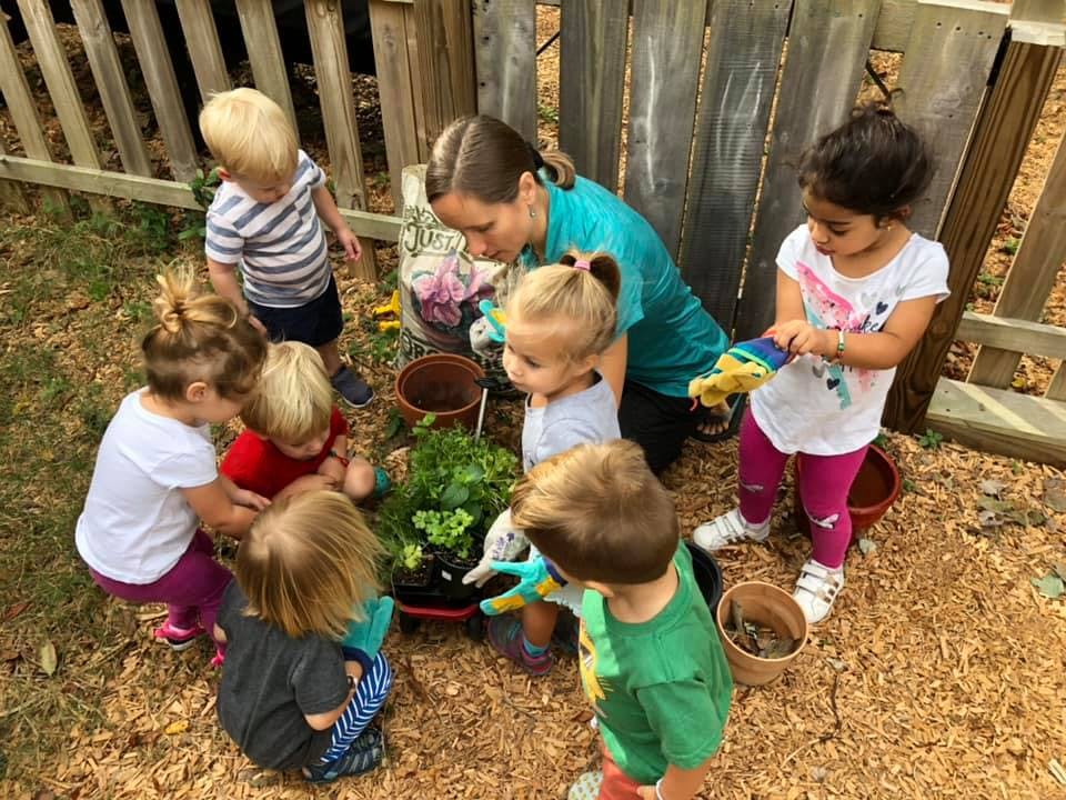 Adult and children planting in a garden