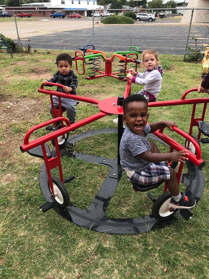 Three children on playground equipment