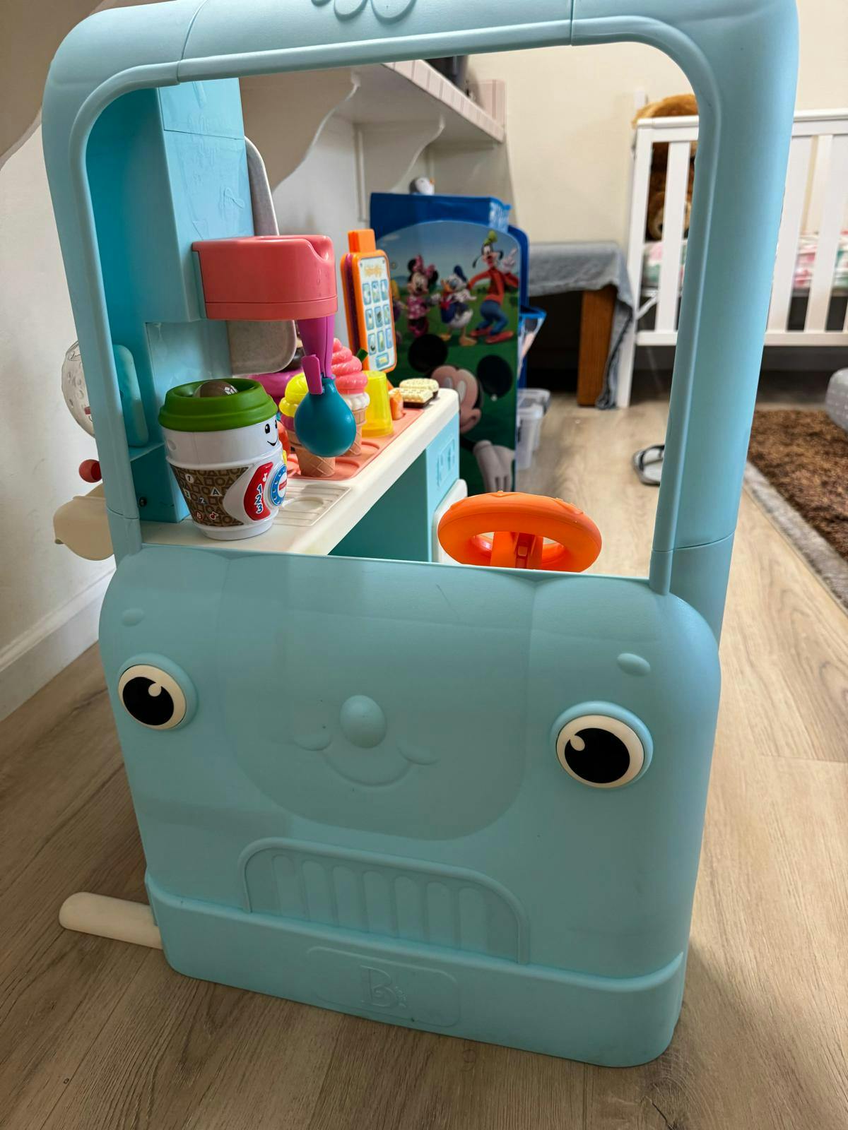 A light blue toy food truck with play food items inside