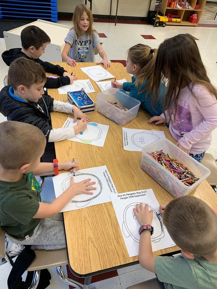 Children drawing at a table in a classroom