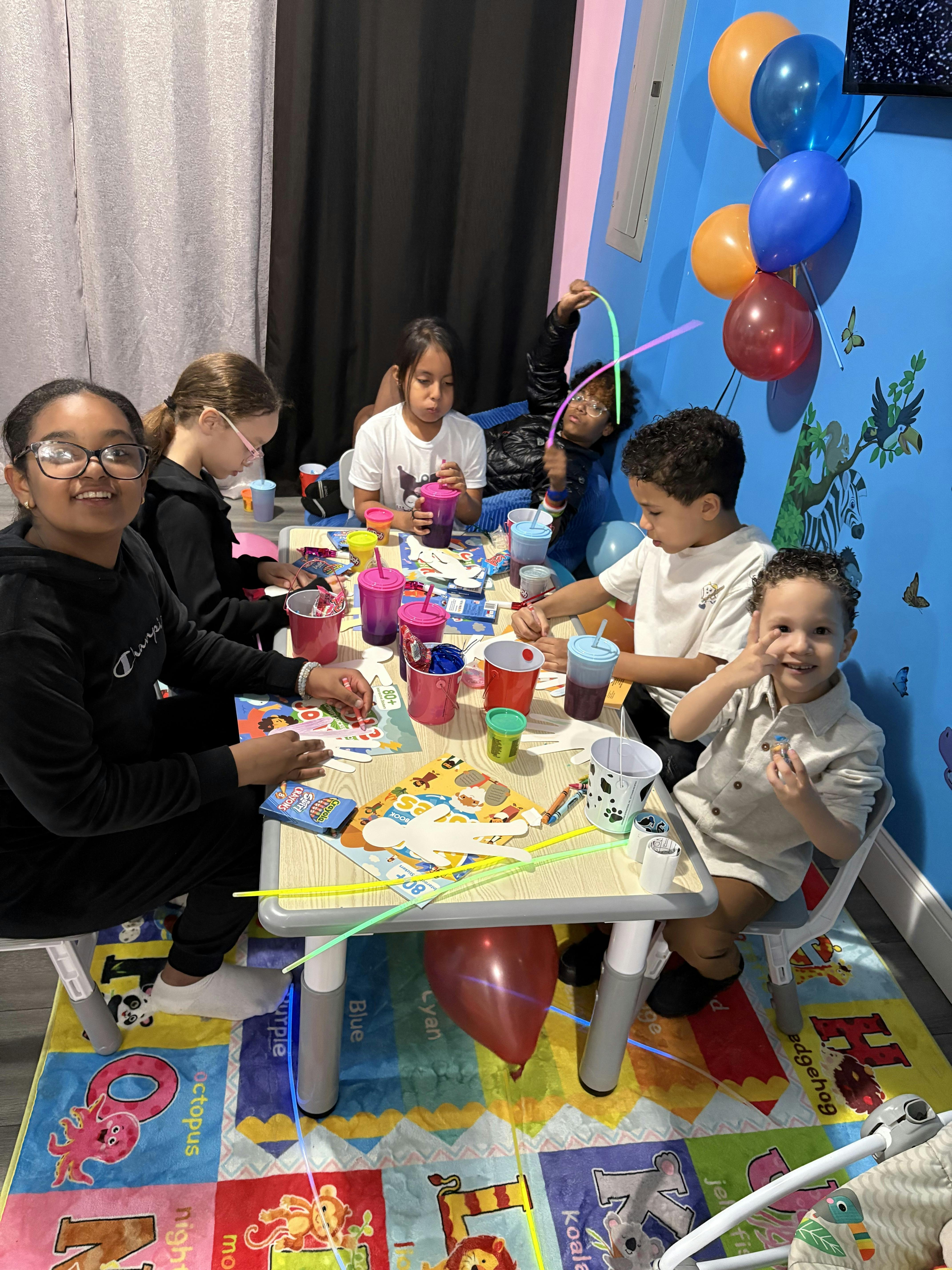 Group of children seated at a small table doing arts and crafts
