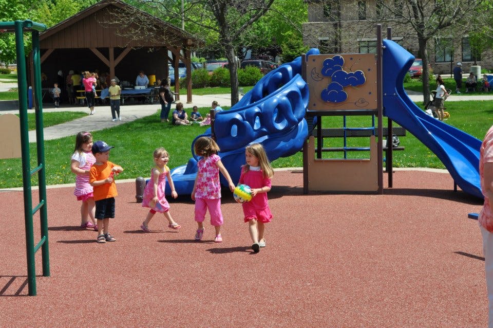 Children playing on a playground with a blue slide