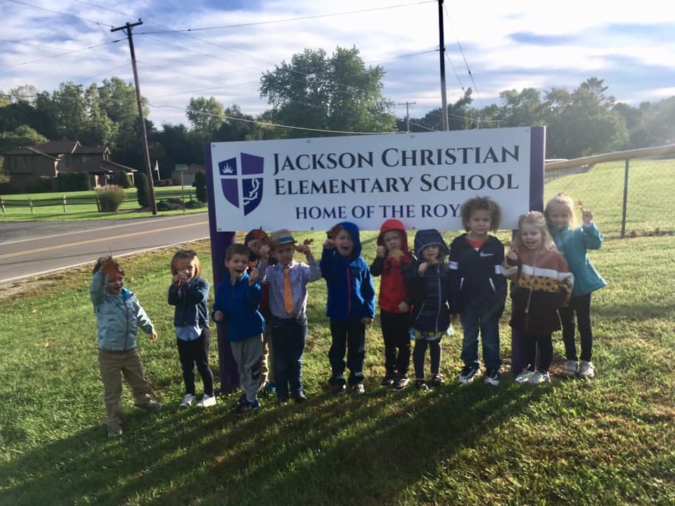 Children standing in front of a sign for Jackson Christian Elementary School