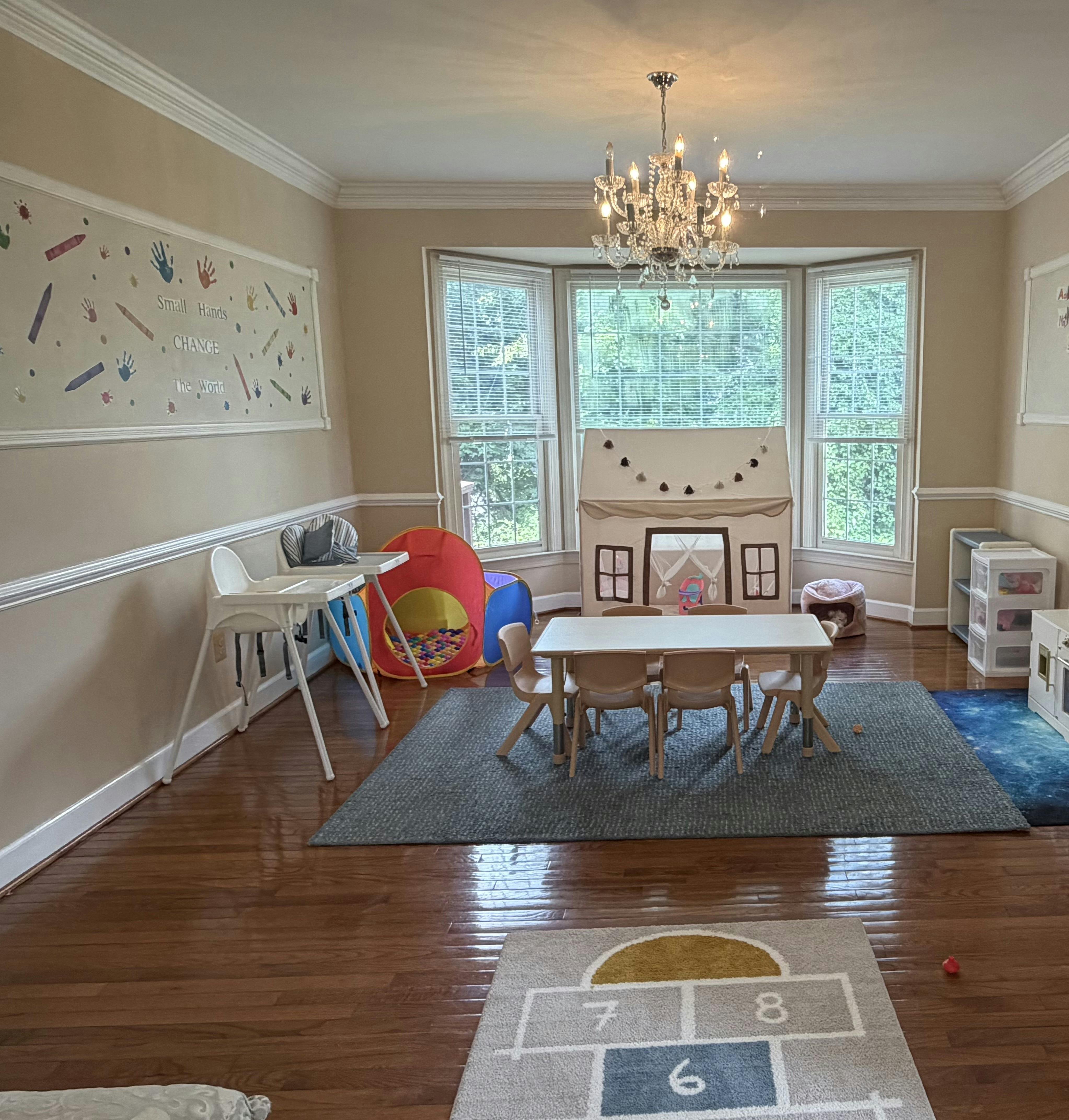 Playroom with a child-sized table, chairs, play tent, and ball pit