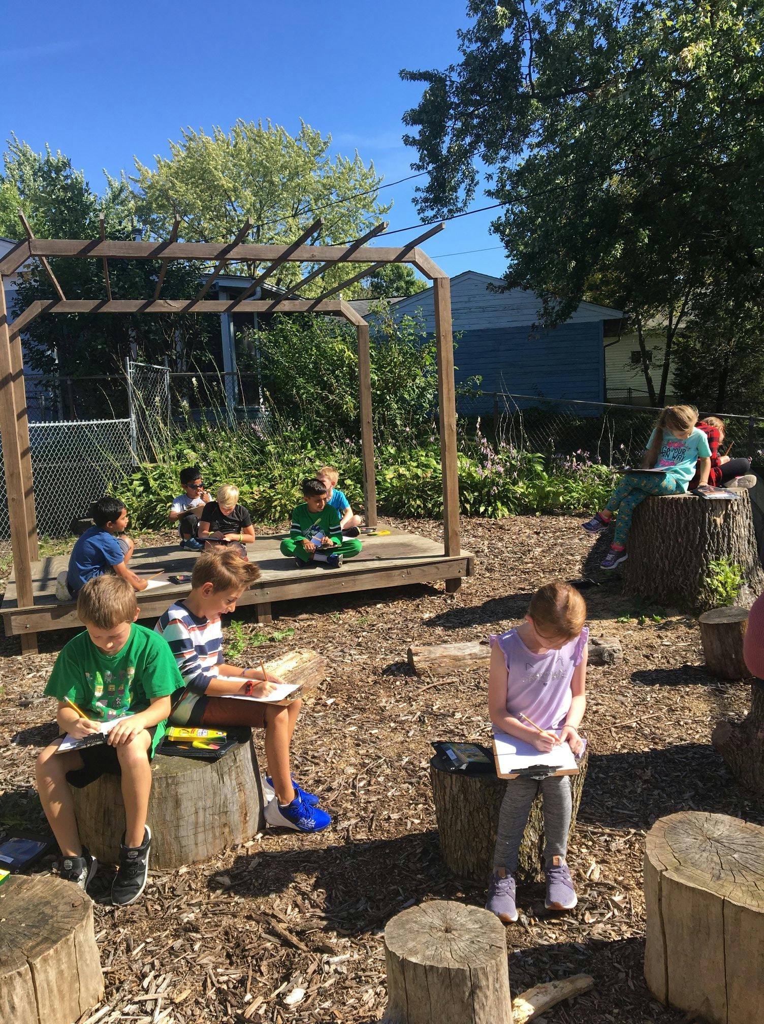 Children writing and drawing outdoors