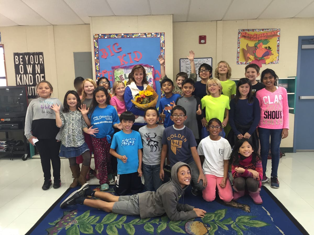 Adult and group of children in a classroom