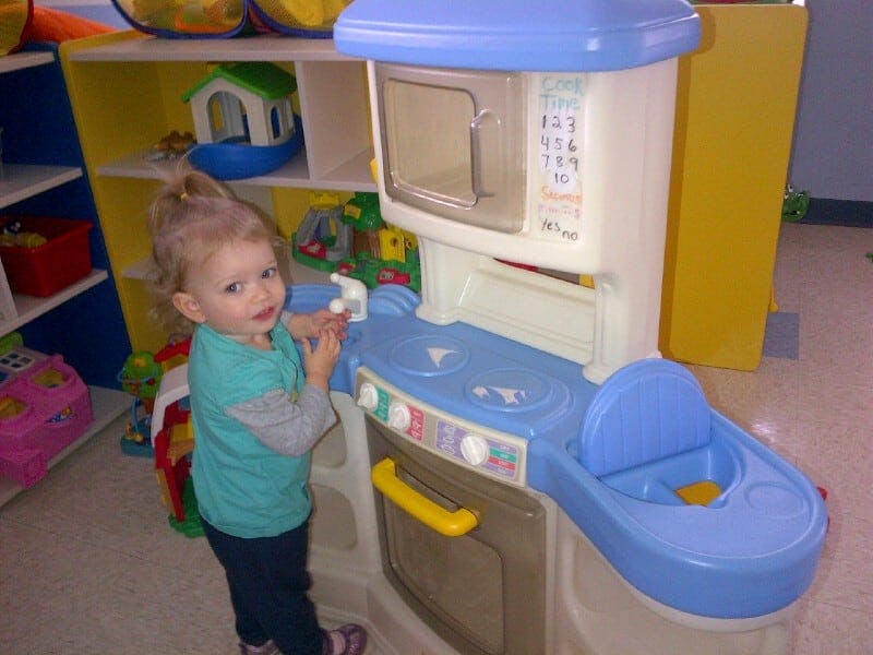 Child playing with a toy kitchen set