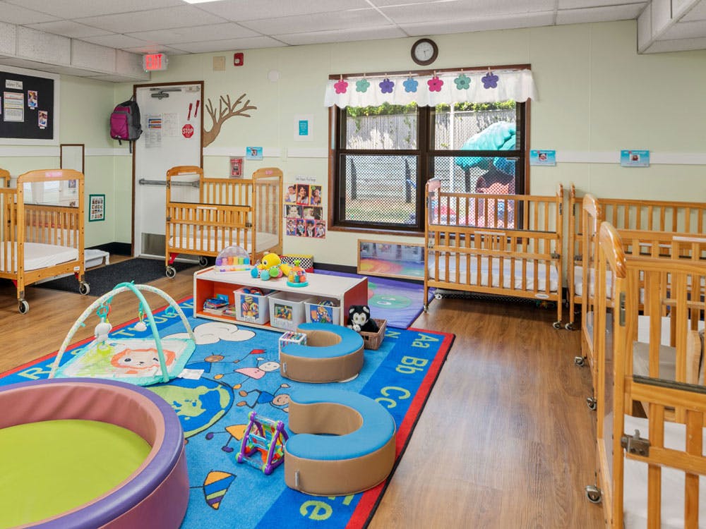 Cribs and play area inside a childcare room