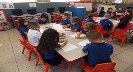 Children sitting at tables in a classroom