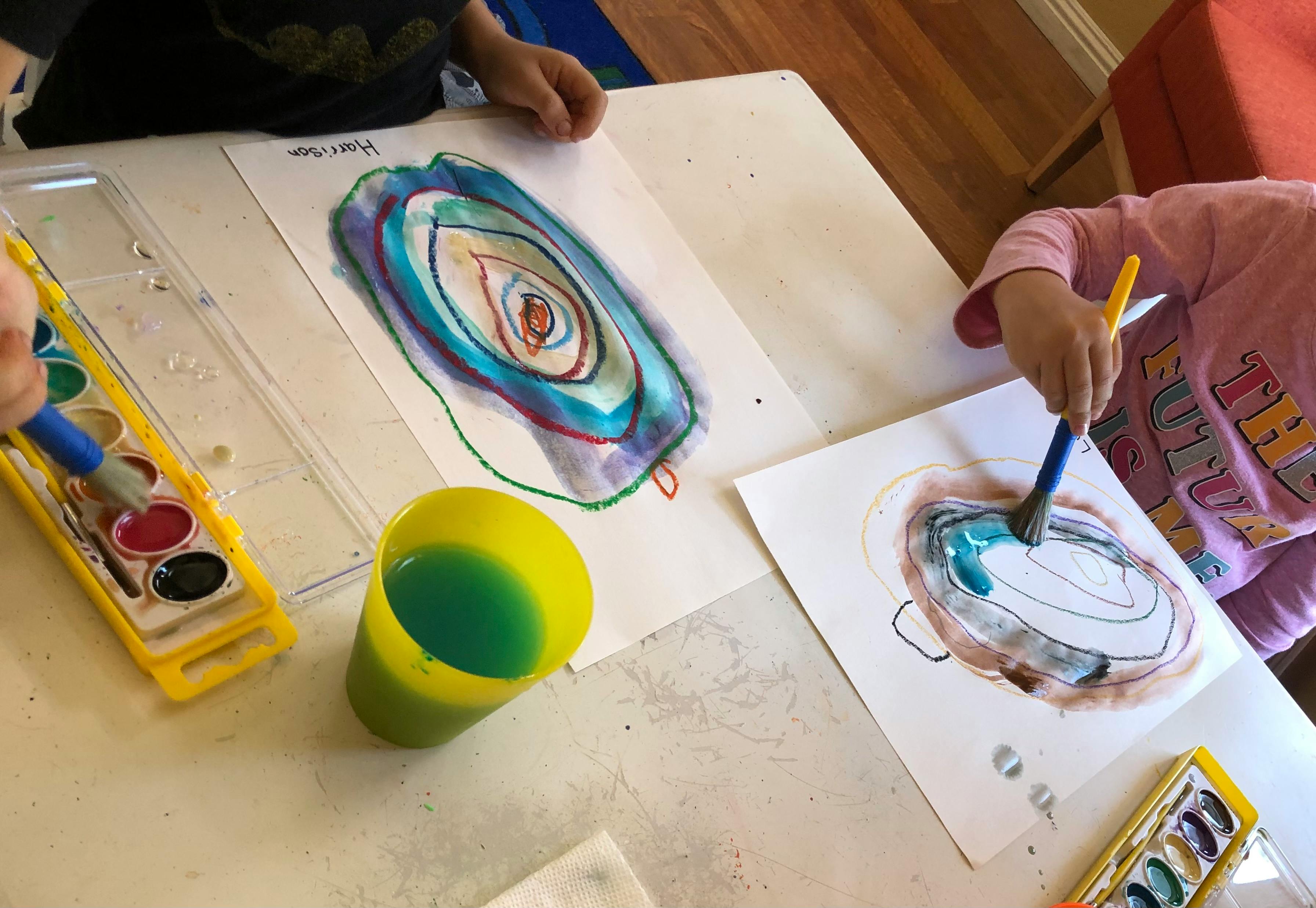 Children painting with watercolors at a table