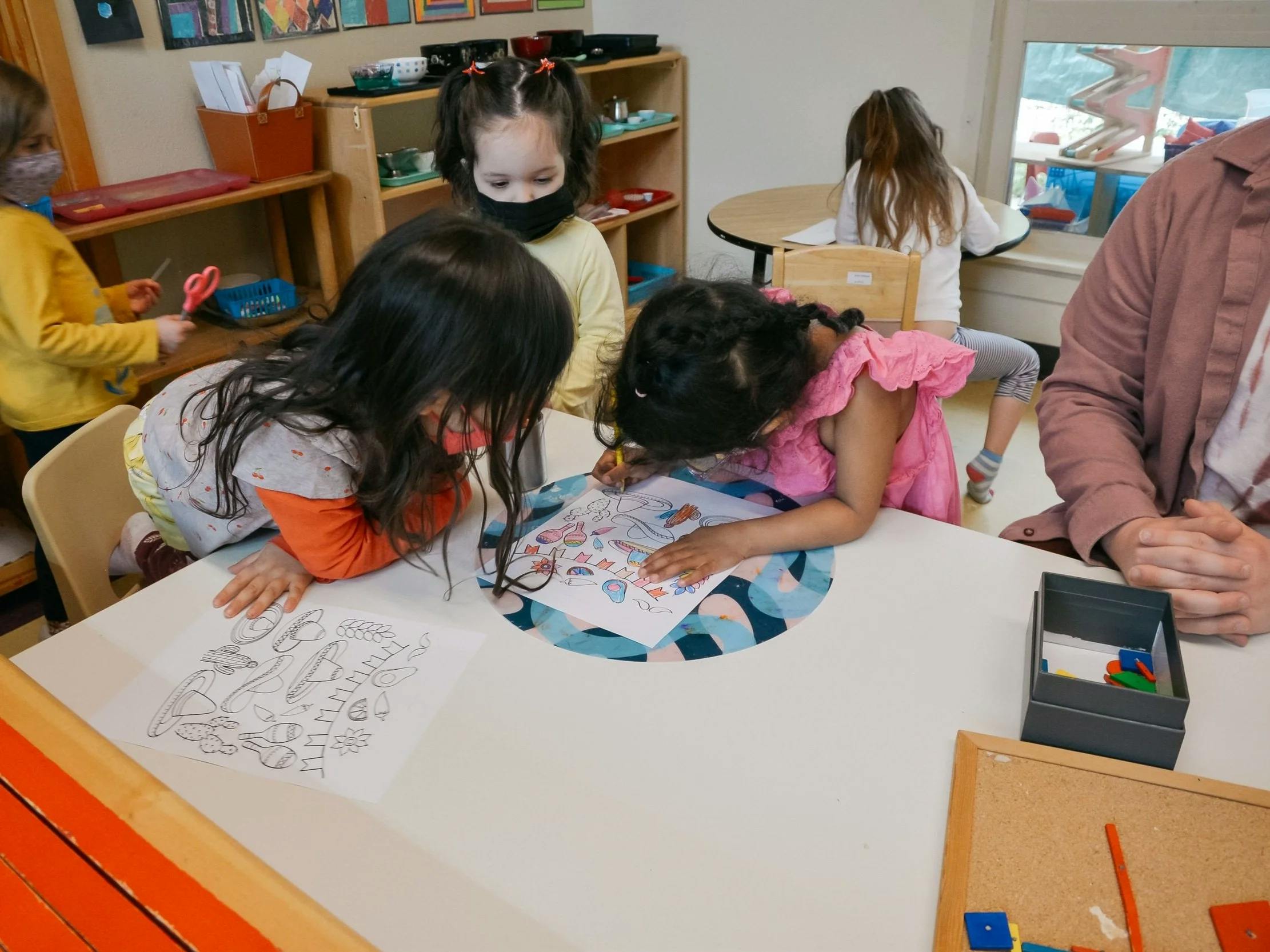 Children coloring at a table in a classroom