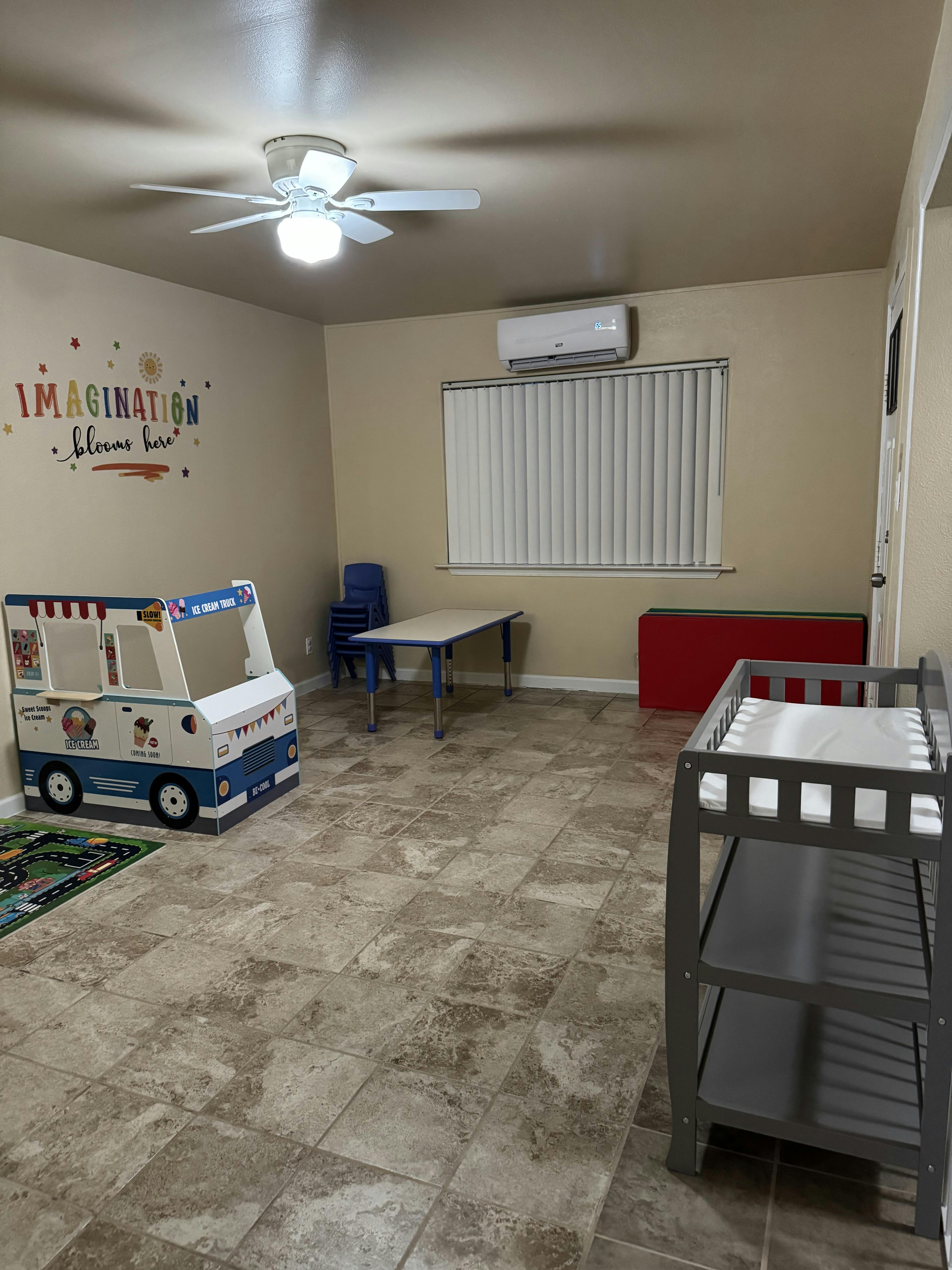 Playroom with toy ice cream truck, table, chairs, and changing table