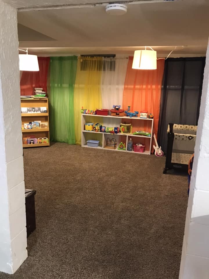 Room with colorful curtains, bookshelves, and toys