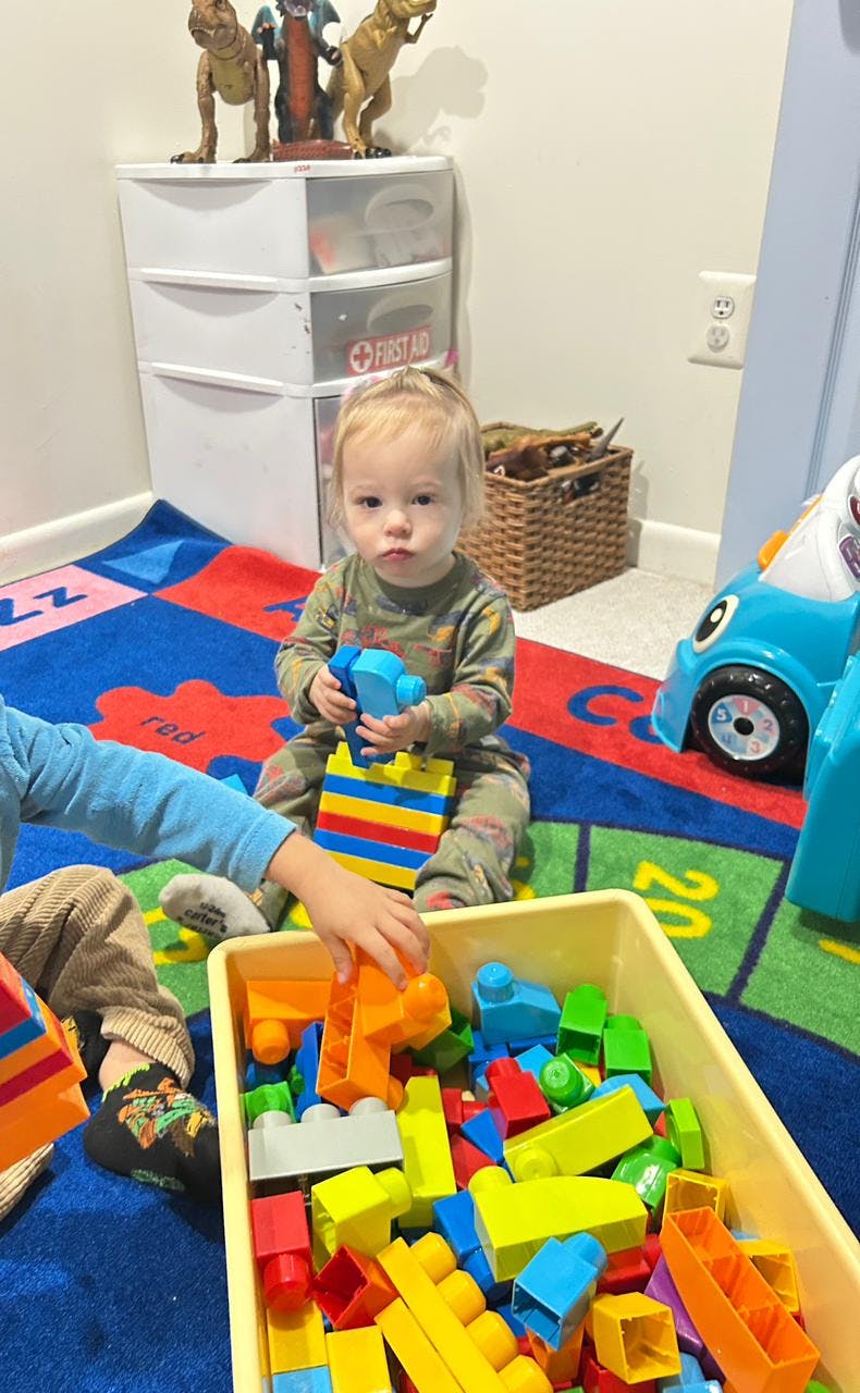 Child playing with colorful building blocks on a rug