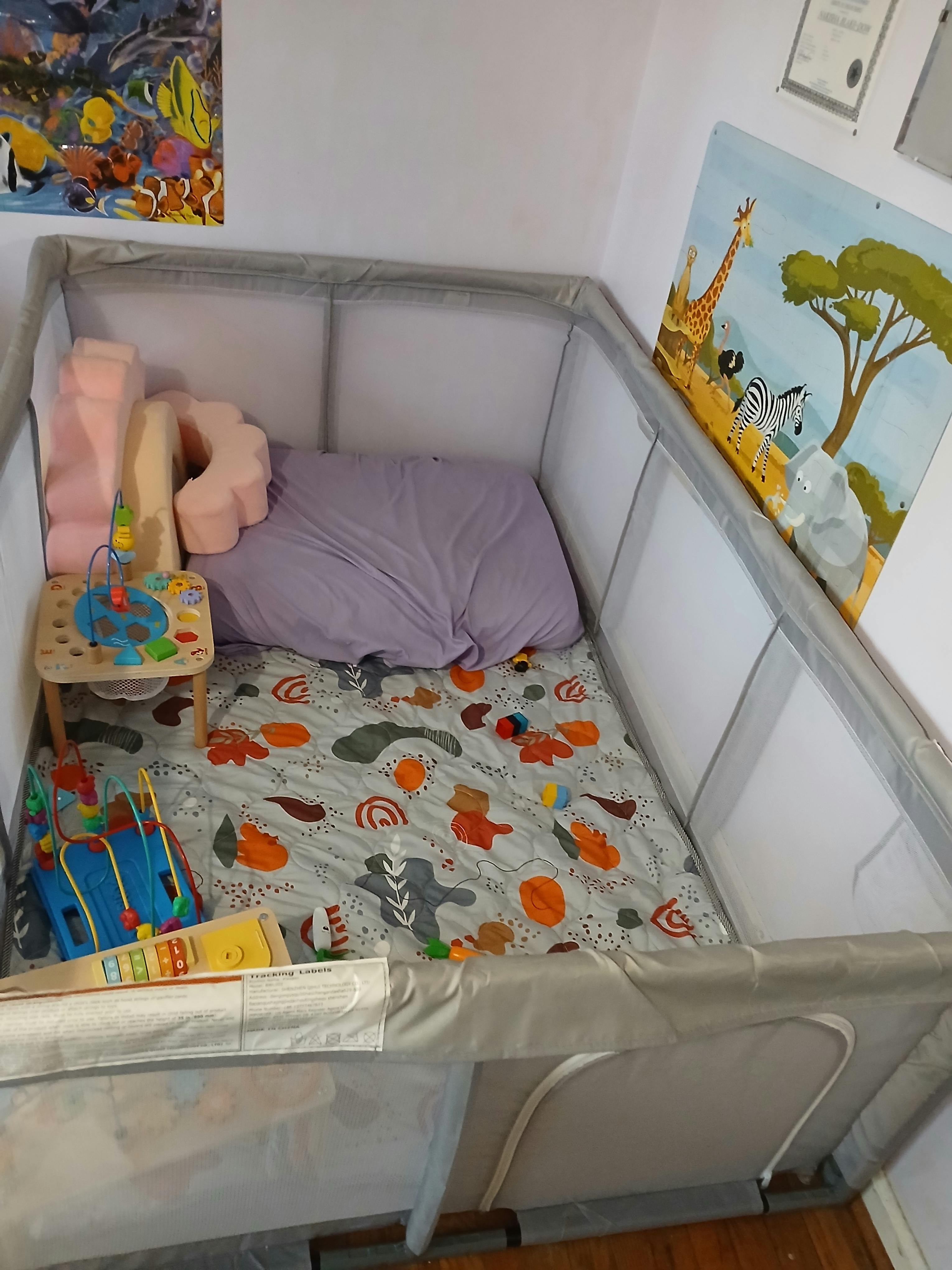 Playpen with a patterned mat and toys
