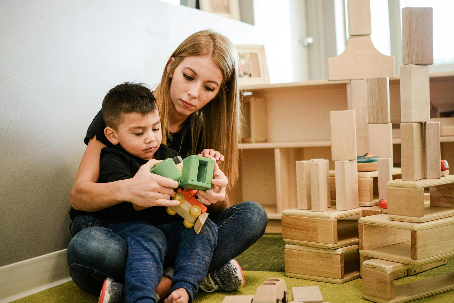 Person and child playing with a toy