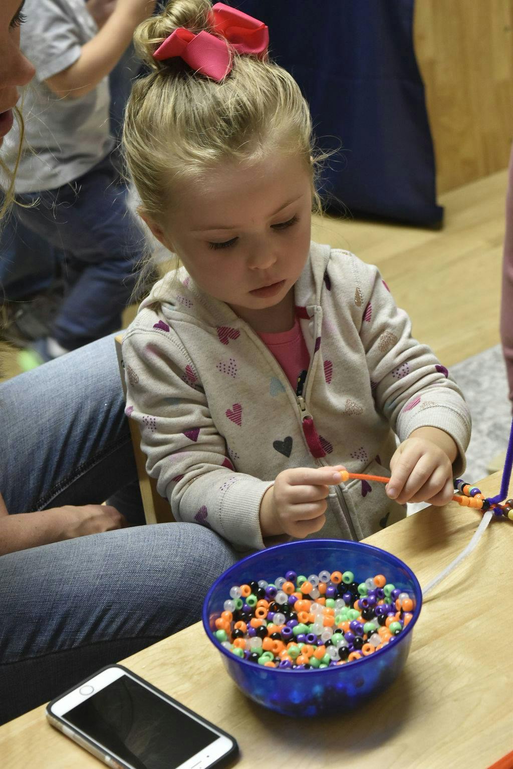 Child making a beaded craft