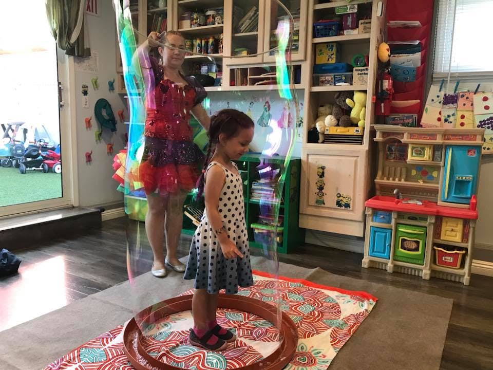 Person making a large bubble around a child
