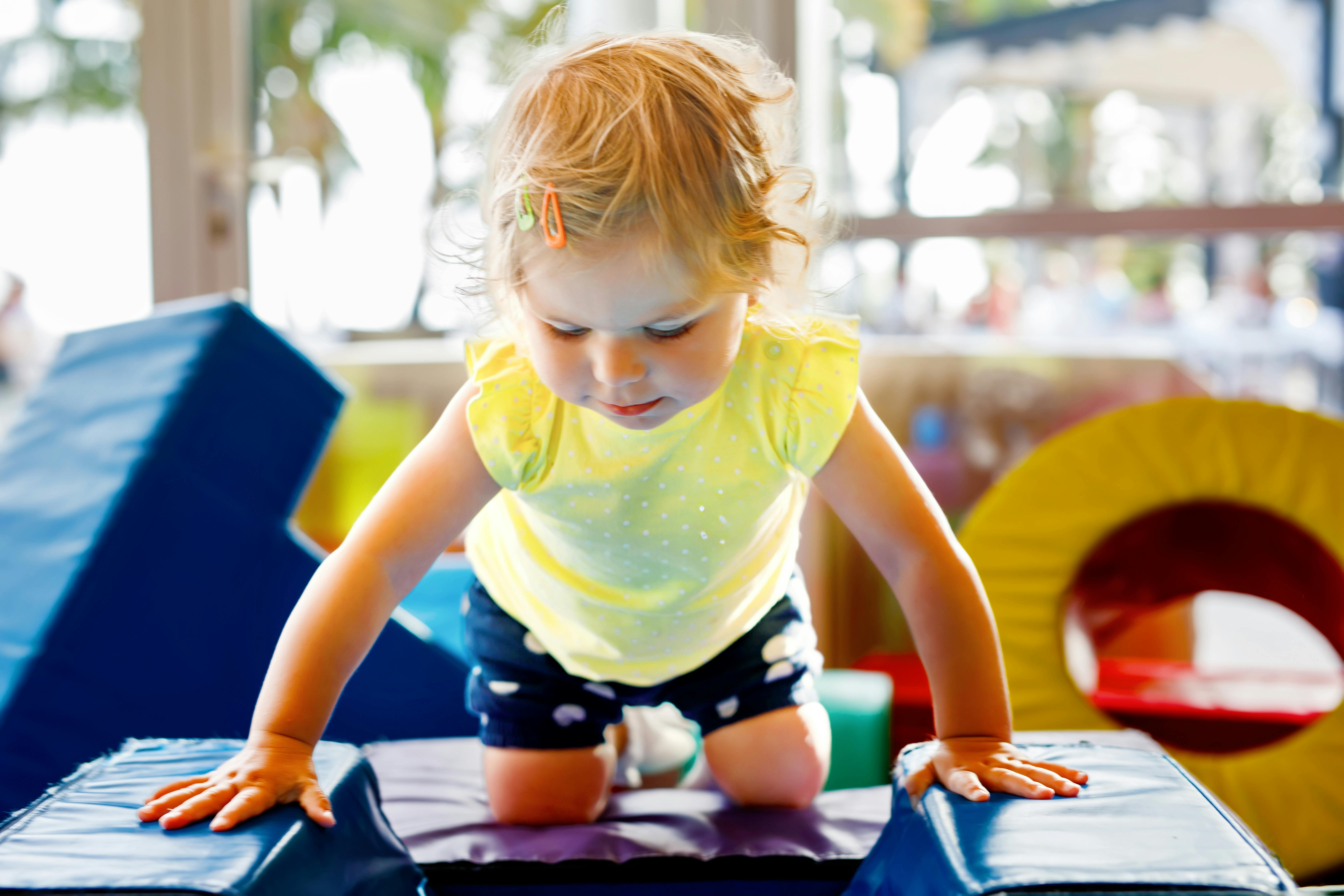 Child crawling on soft play equipment