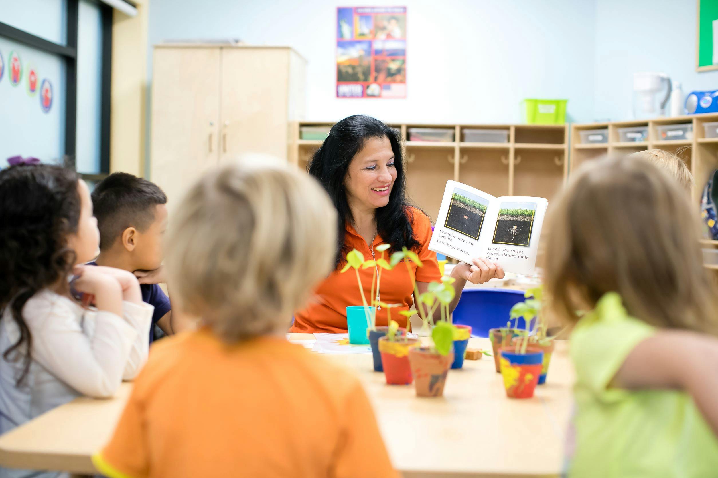 Person reading a book to children in a classroom