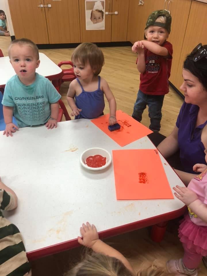 Children and an adult at a table with art supplies