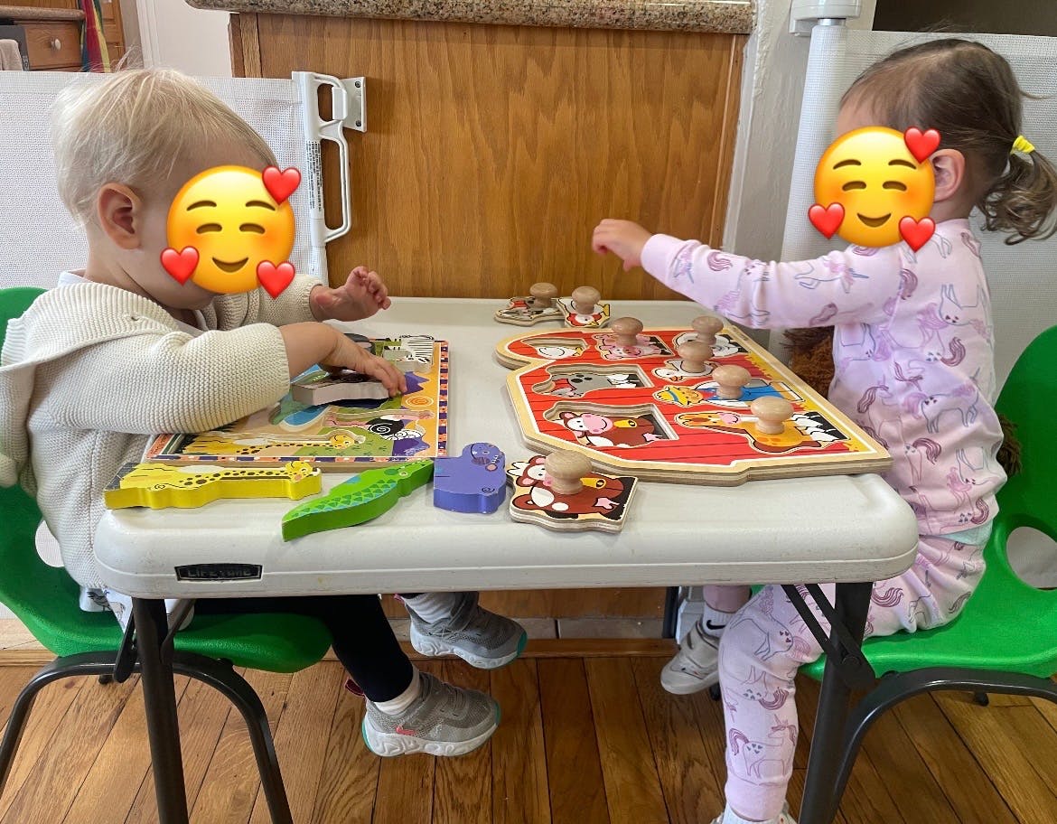 Two children playing with puzzles at a table