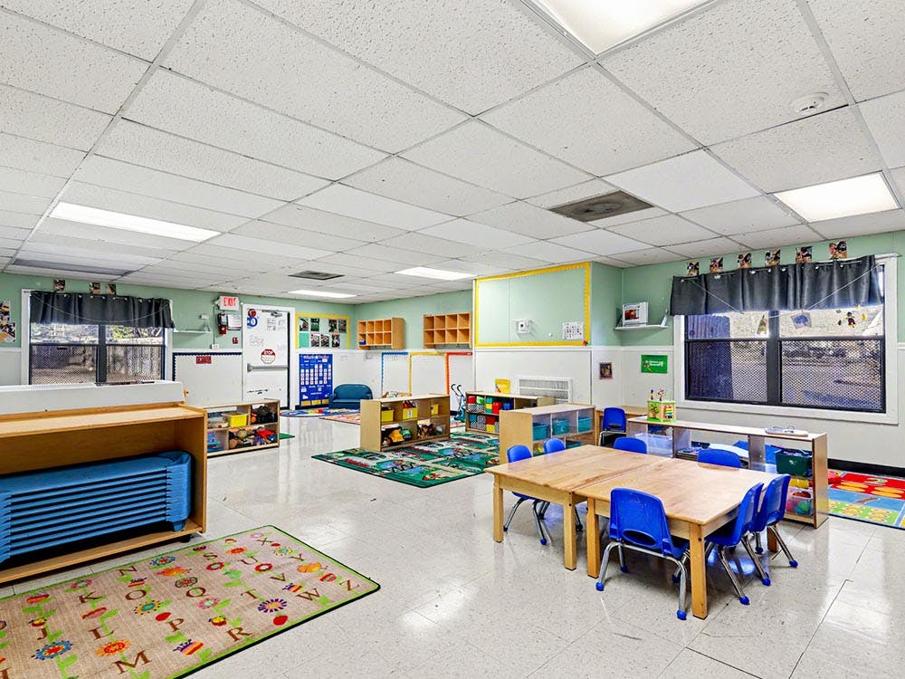 Empty colorful children's classroom with small tables and chairs