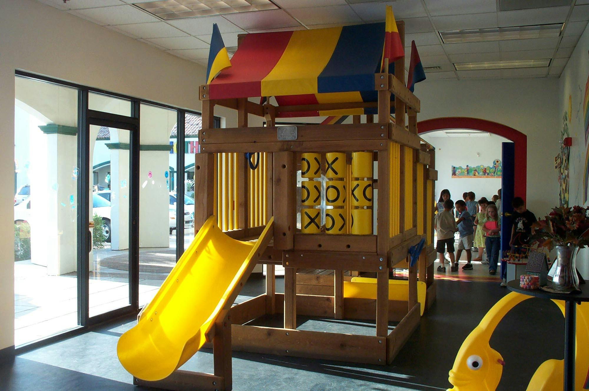 Indoor playground with a yellow slide and tic-tac-toe game