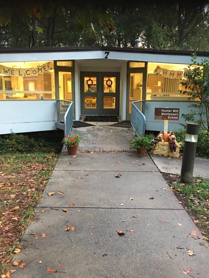 Building entrance with double doors, railings, and a sign that reads "Hunter Mill Montessori School"