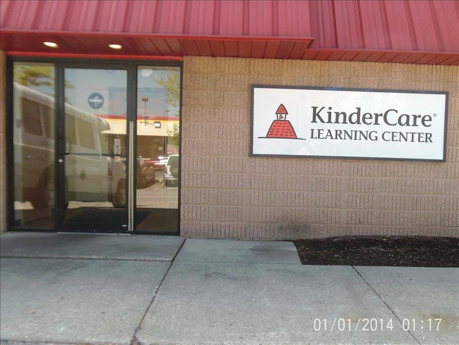 KinderCare Learning Center sign on a brick building with glass doors