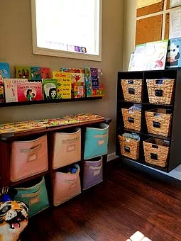 Books on a shelf above storage bins