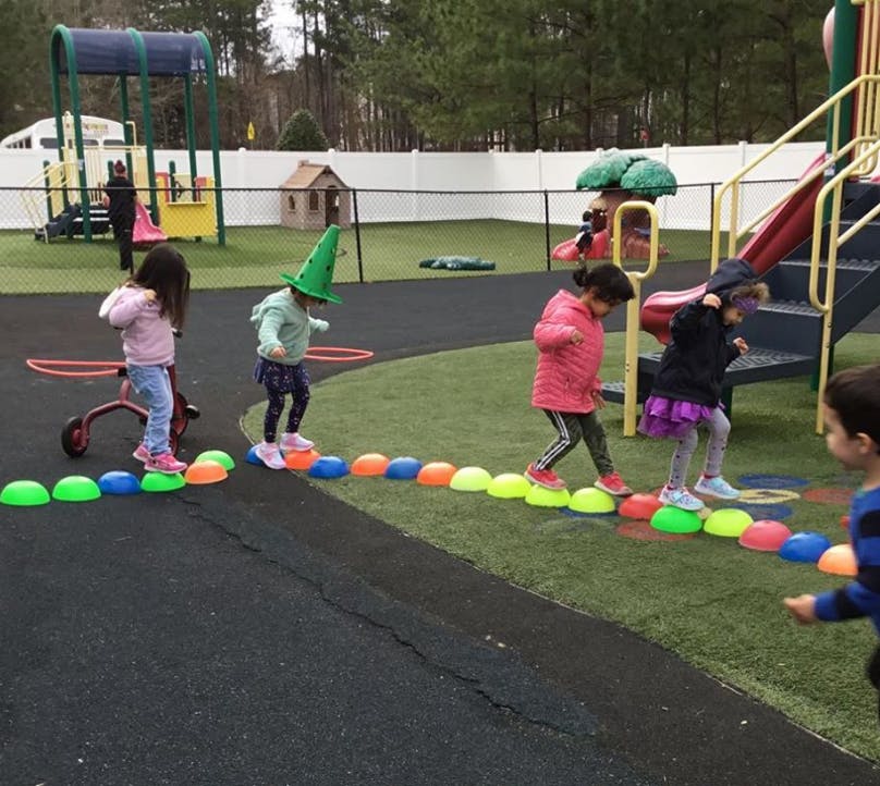 Children walking on colorful stepping stones on a playground