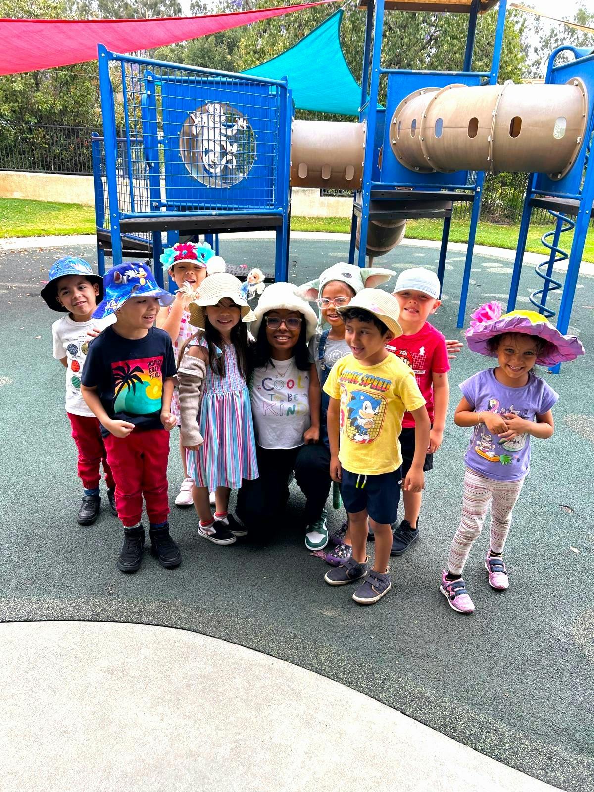 Group of children and one adult posing on a playground