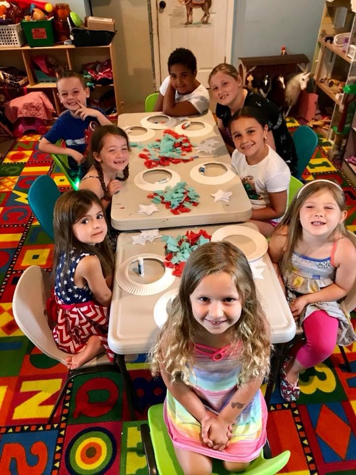 Group of children sitting around a table with craft supplies